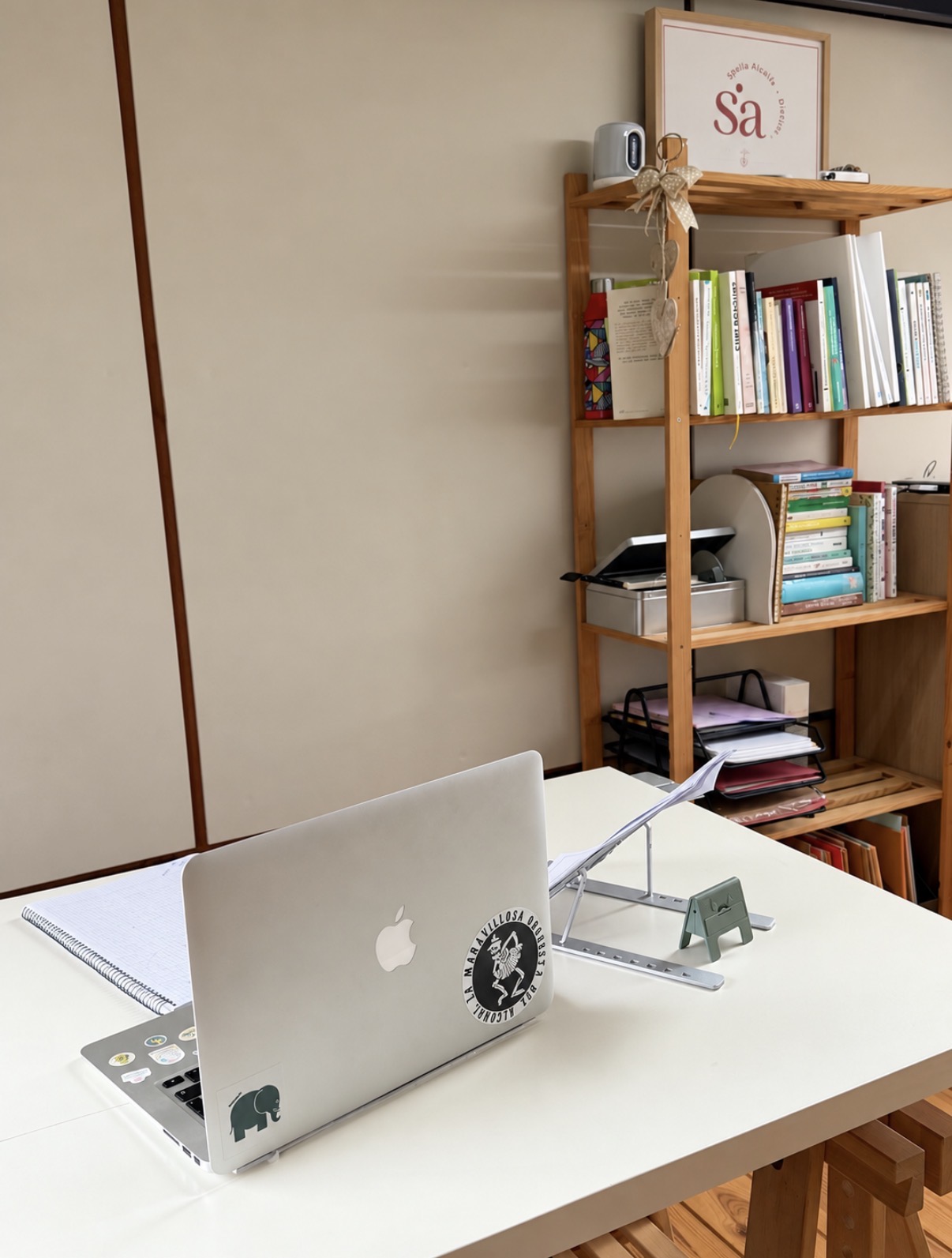 Escritorio y estantería con libros y el logo de SAC Nutrición